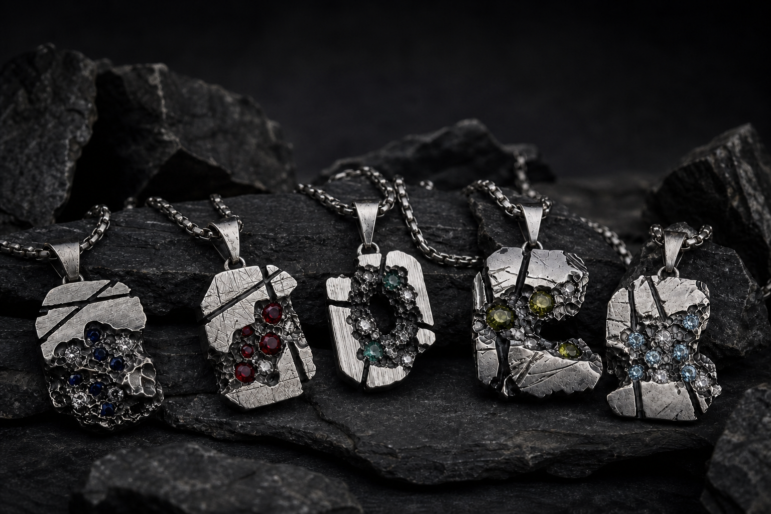 The five IBBY HAMZA pendants arranged together on dark stone